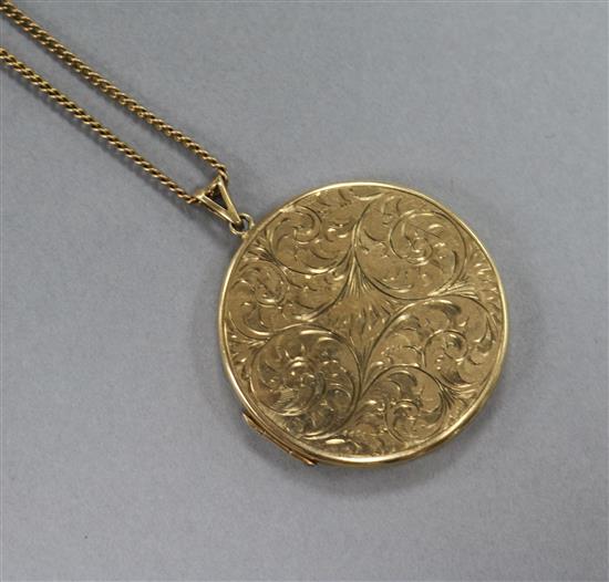 An engraved 9ct gold locket on a 9ct gold chain, locket 43mm.